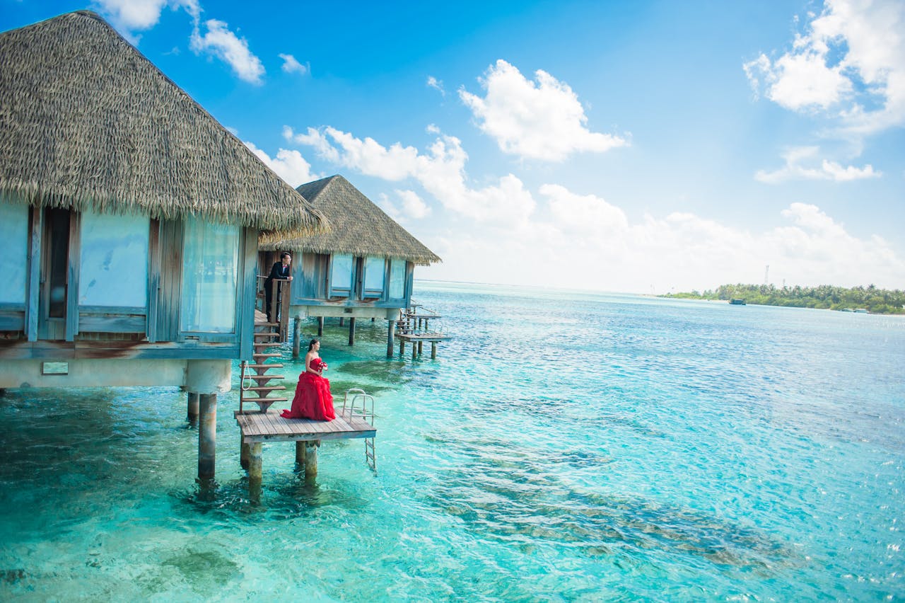 services-03 Idyllic Maldives overwater bungalows with turquoise lagoon and a couple enjoying paradise.