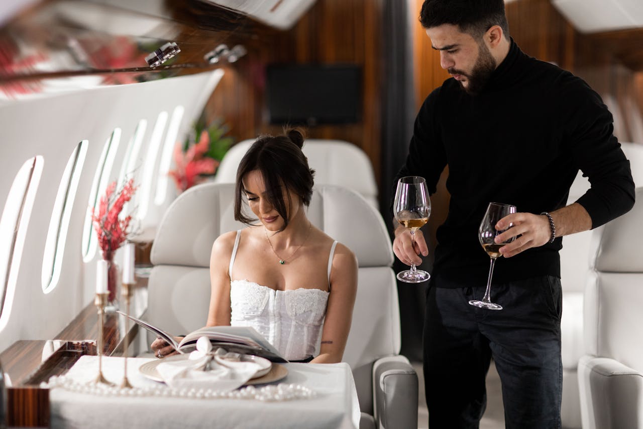 about-01 Elegant couple enjoying wine in a luxurious private jet interior.