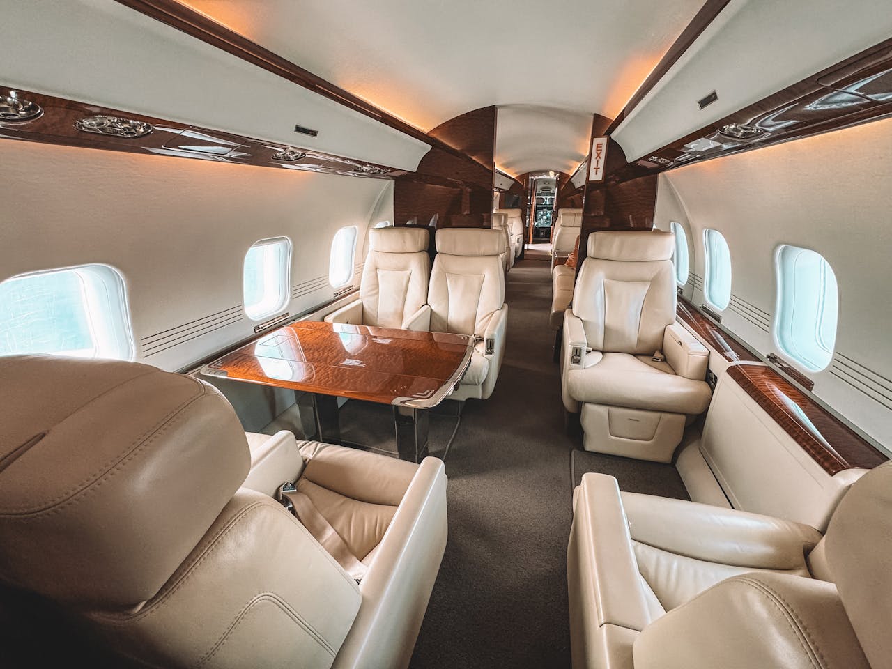 why-choose-us Luxurious interior of a private jet showcasing leather seating and elegant wooden trim.
