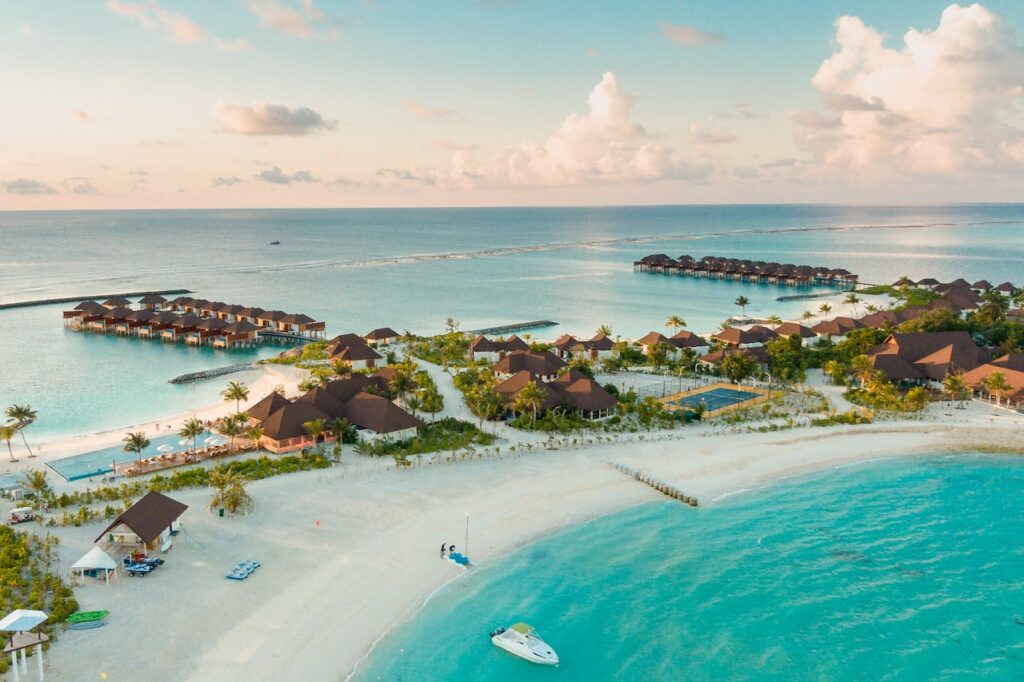 Home Stunning aerial view of a luxurious tropical resort in the Maldives, showcasing overwater bungalows and turquoise waters.